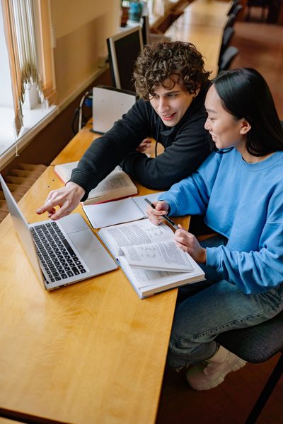 Dois estudantes analisando uma plataforma de estudos para concursos