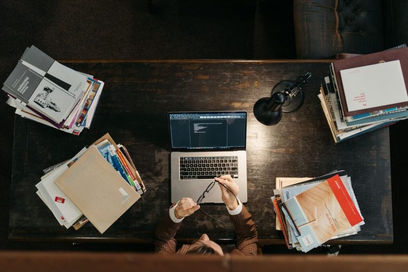 Curso preparatório para técnico judiciário com livros, caderno e notebook na mesa de estudos