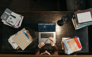 Curso preparatório para técnico judiciário com livros, caderno e notebook na mesa de estudos
