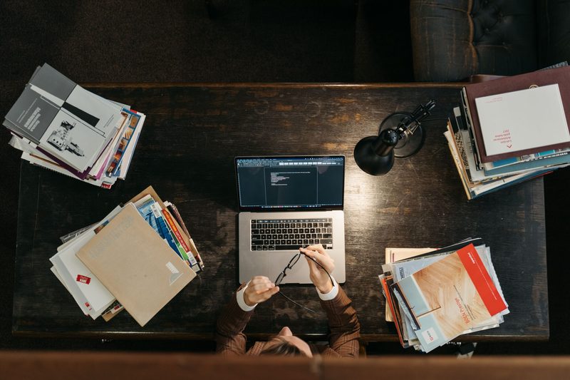 Curso preparatório para técnico judiciário com livros, caderno e notebook na mesa de estudos