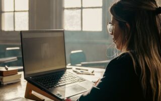 Estudante usando notebook para comparar cursos preparatórios para concursos