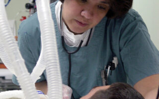 Técnico de enfermagem em atendimento a paciente em unidade de terapia intensiva