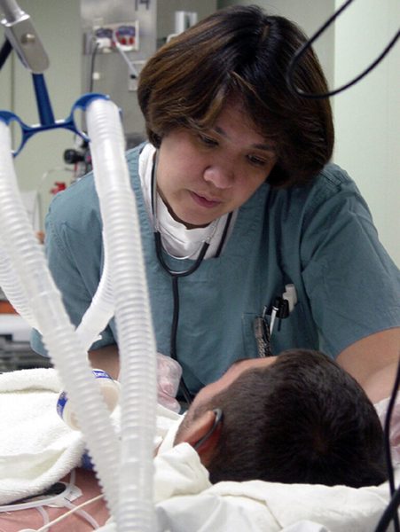 Técnico de enfermagem em atendimento a paciente em unidade de terapia intensiva