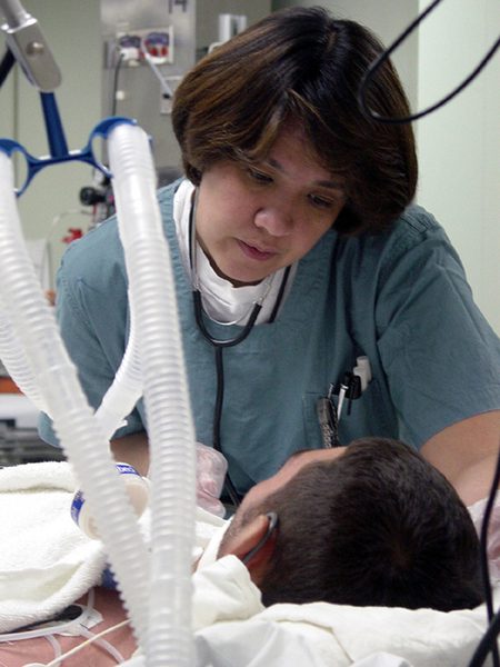 Técnico de enfermagem em atendimento a paciente em unidade de terapia intensiva