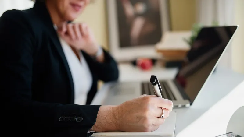 Profissional analisa documentos em ambiente de trabalho ligado à formação em Administração