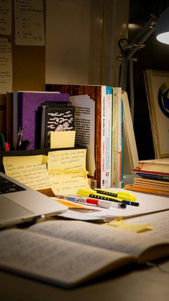 Mesa com livro, notebook e materiais do curso técnico em Administração