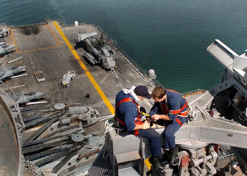 Técnicos em eletrônica fazem manutenção em equipamento de radar