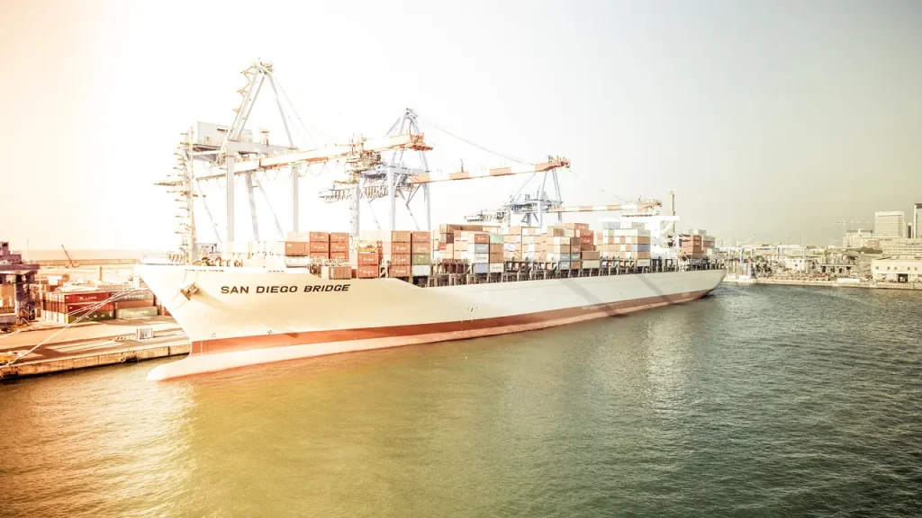 Navio porta-contêineres atracado em terminal portuário, imagem sobre técnico em Comércio Exterior e drawback