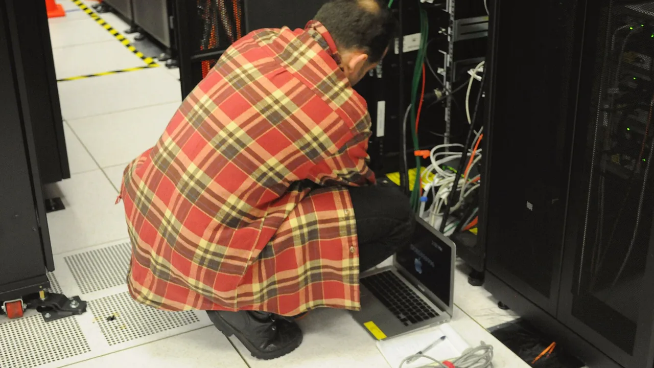 Técnico em Informática trabalhando em rack de servidores para cibersegurança