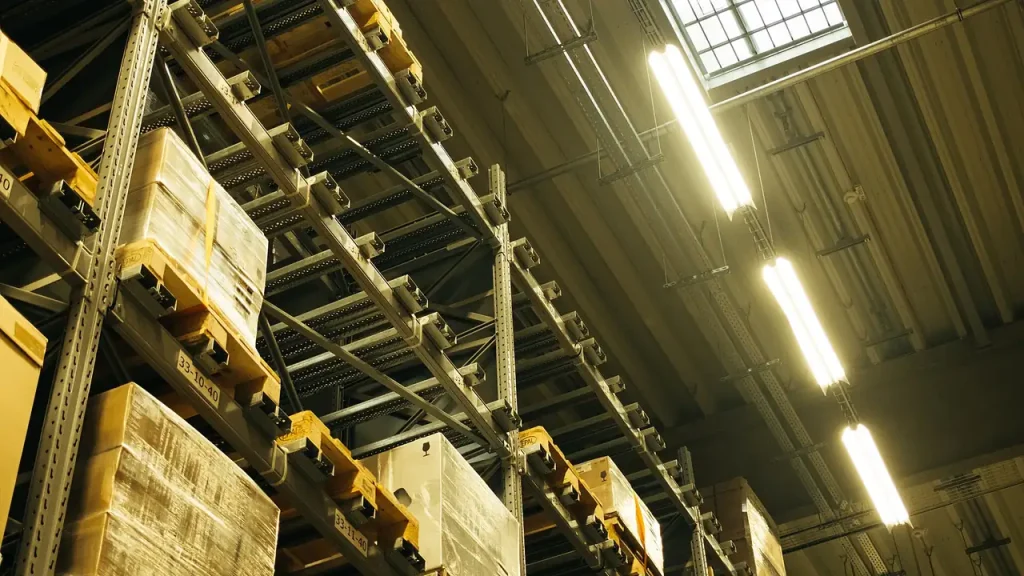 Técnico em Logística em armazém com prateleiras e estoque organizado para planejamento de demanda