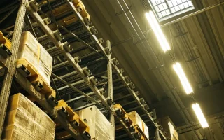 Técnico em Logística em armazém com prateleiras e estoque organizado para planejamento de demanda