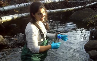 Técnico em Meio Ambiente coleta amostra de água em atividade de campo