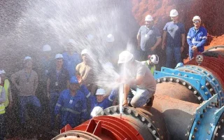 Técnicos industriais atuando em sistema de saneamento durante manutenção de tubulação