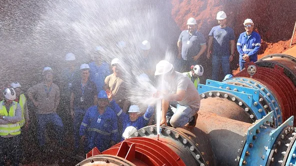Técnicos industriais atuando em sistema de saneamento durante manutenção de tubulação