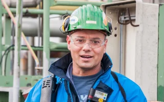 Curso técnico em Segurança do Trabalho: profissional usando capacete e óculos de proteção em ambiente industrial