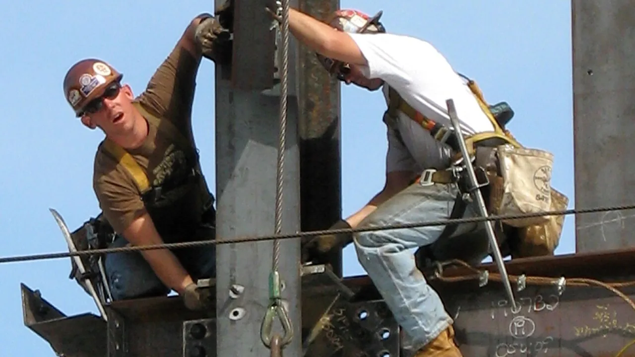 Trabalhadores em atividade de construção com equipamentos de proteção e prevenção de riscos